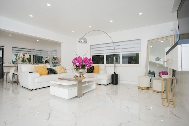 living area with recessed lighting and marble finish floor