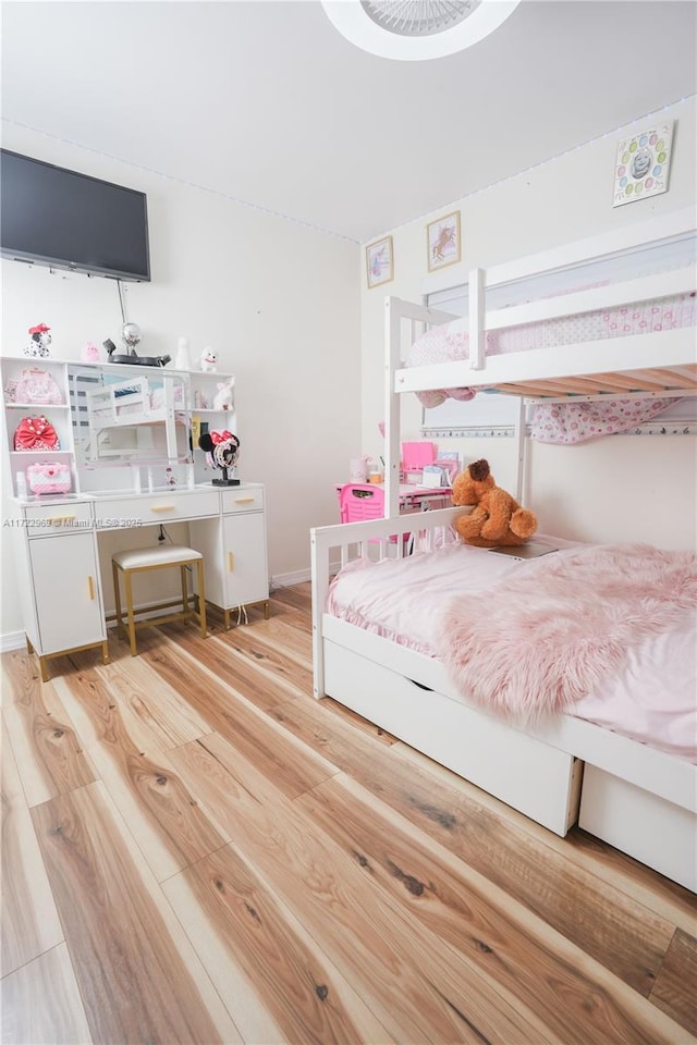 bedroom with light wood finished floors and baseboards