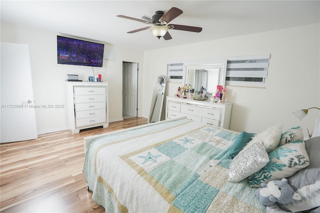 bedroom with baseboards, a ceiling fan, and light wood-style floors