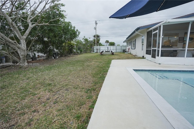 view of yard featuring an outdoor pool, a sunroom, a patio, and fence