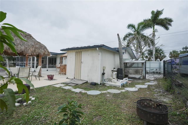 rear view of house featuring an outdoor fire pit, a patio area, a fenced backyard, and an outdoor structure