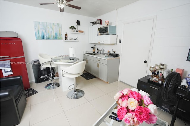 bathroom featuring ceiling fan, a sink, and tile patterned floors