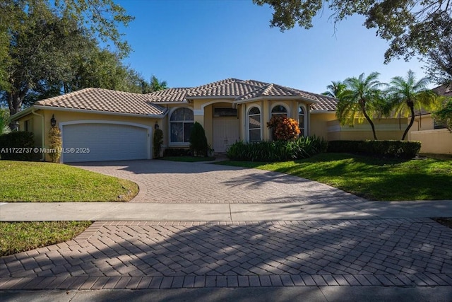 mediterranean / spanish-style home with a front yard and a garage