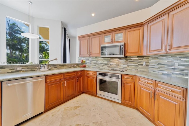 kitchen with tasteful backsplash, light stone countertops, sink, and stainless steel appliances