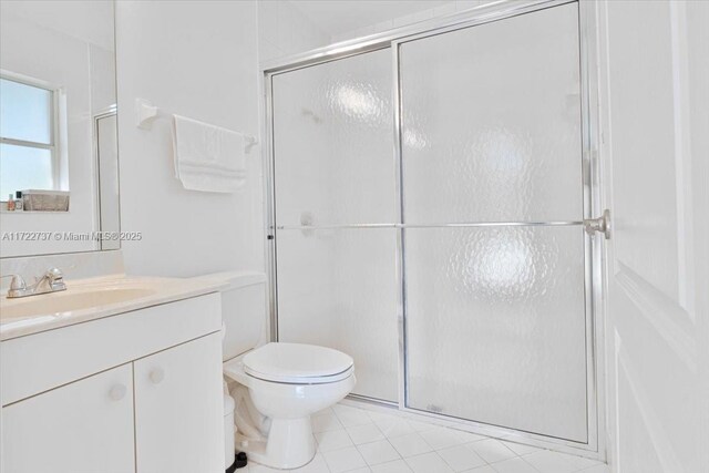 bathroom featuring a shower with door, vanity, and toilet