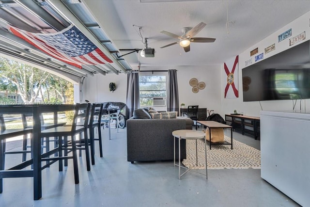 living room with ceiling fan, a healthy amount of sunlight, and concrete floors