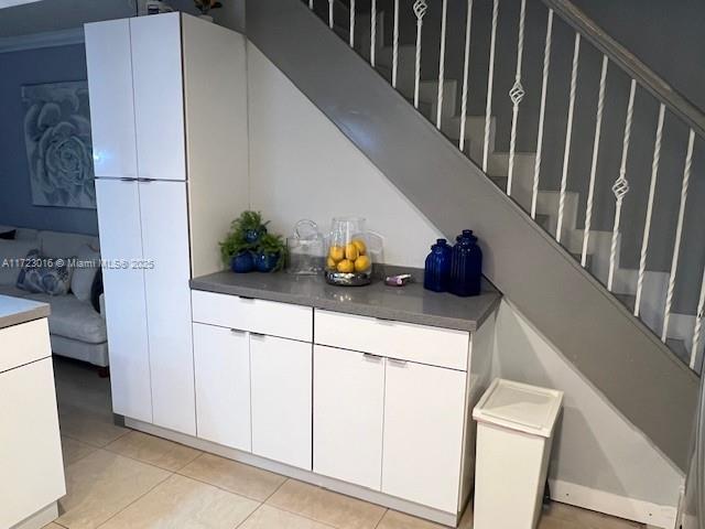 interior space with light tile patterned floors and white cabinets