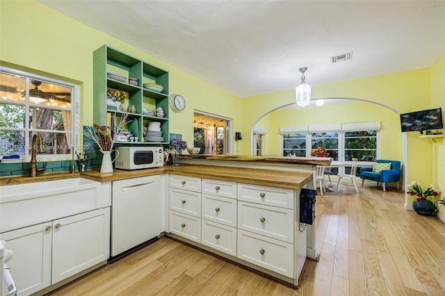 kitchen with white cabinetry, wood counters, plenty of natural light, decorative light fixtures, and white appliances