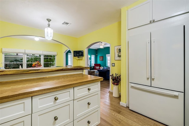 kitchen featuring light hardwood / wood-style floors, pendant lighting, white cabinets, butcher block countertops, and white built in refrigerator