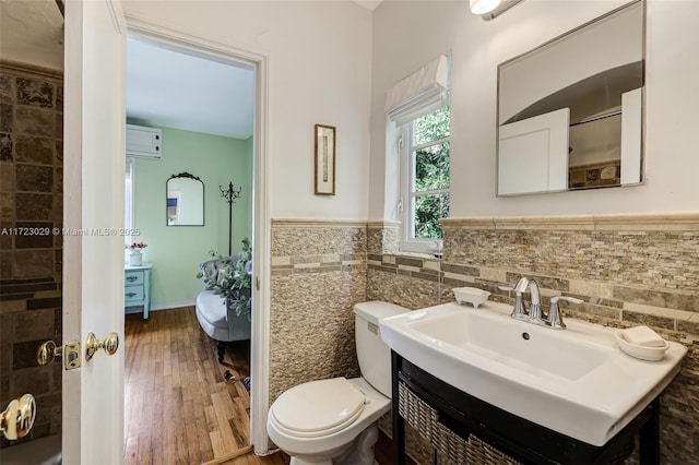 bathroom featuring hardwood / wood-style flooring, vanity, tile walls, and toilet