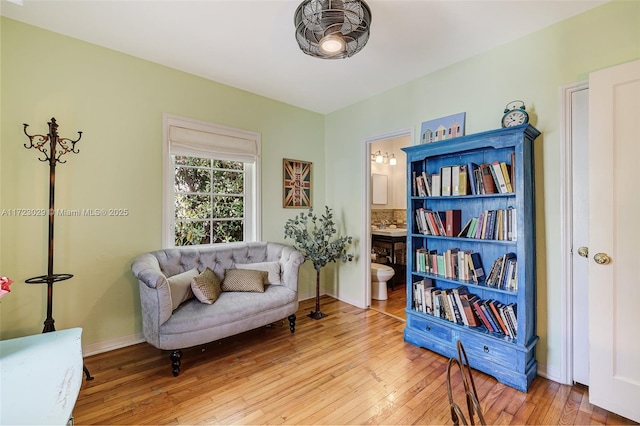 sitting room with ceiling fan and hardwood / wood-style flooring