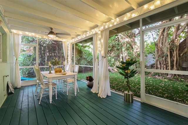 unfurnished sunroom with beamed ceiling and ceiling fan