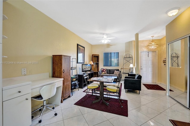 home office with ceiling fan with notable chandelier and light tile patterned floors