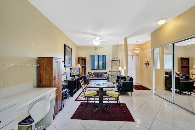 tiled living room with ceiling fan with notable chandelier