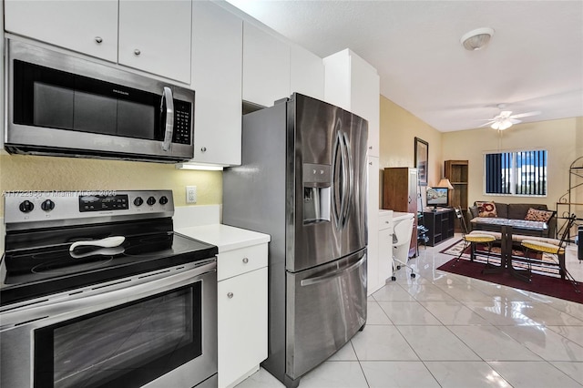 kitchen featuring ceiling fan, white cabinetry, light tile patterned floors, and appliances with stainless steel finishes