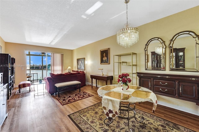 interior space with hardwood / wood-style floors, a textured ceiling, and an inviting chandelier