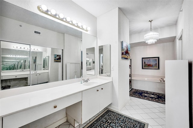 bathroom featuring a washtub, an inviting chandelier, tile patterned floors, a textured ceiling, and vanity