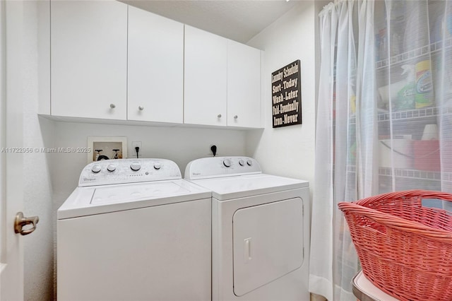 laundry area with washer and dryer and cabinets