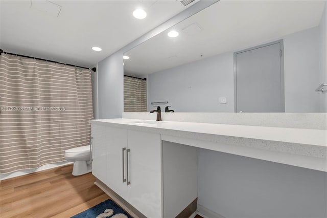 bathroom with toilet, recessed lighting, a shower with shower curtain, wood finished floors, and vanity