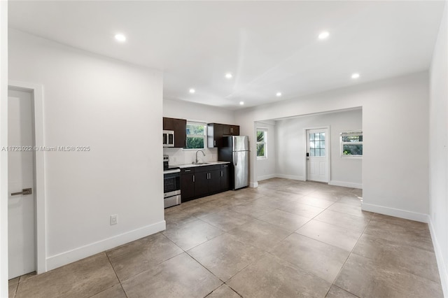 kitchen with appliances with stainless steel finishes, dark brown cabinetry, and sink