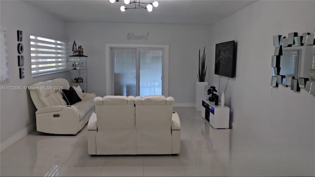 tiled living room with a notable chandelier