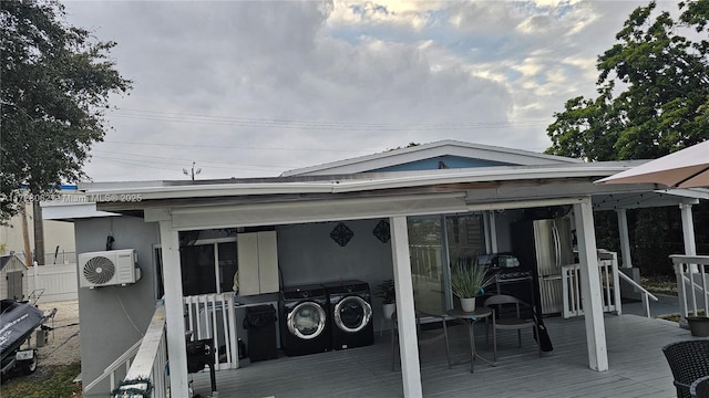 back of house featuring washing machine and dryer and a deck