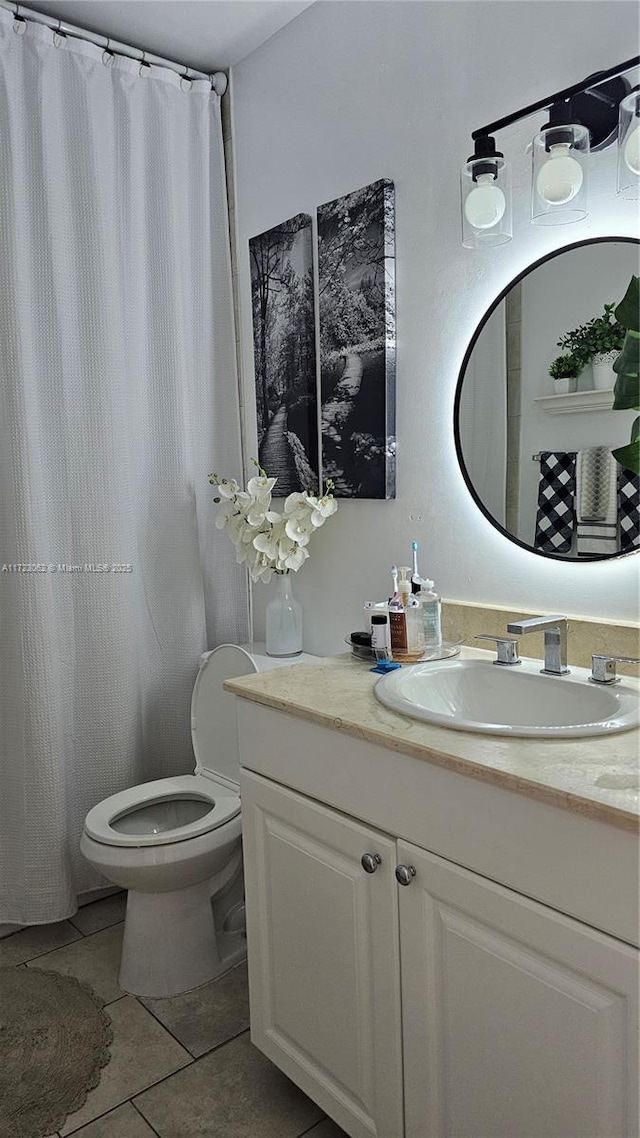 bathroom with tile patterned flooring, vanity, and toilet