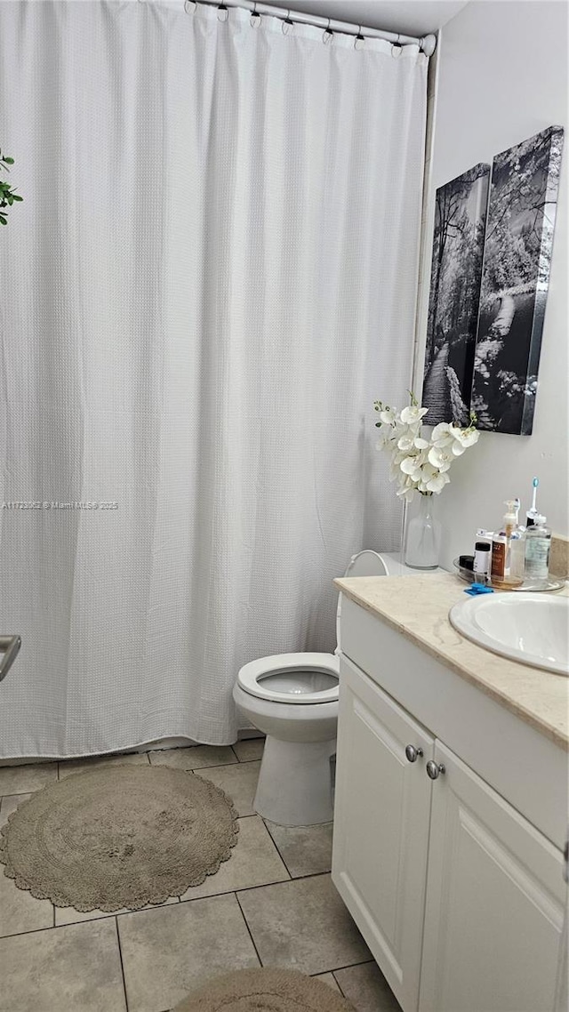 bathroom with tile patterned flooring, vanity, and toilet