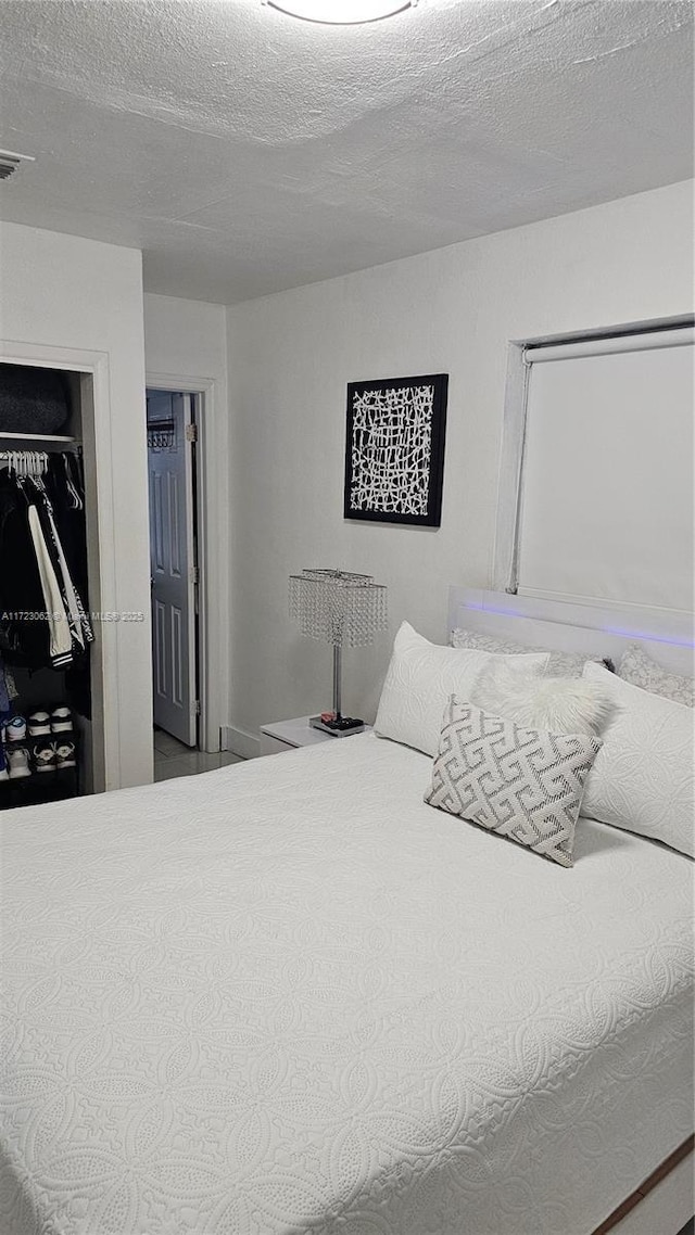 bedroom featuring a textured ceiling and a closet