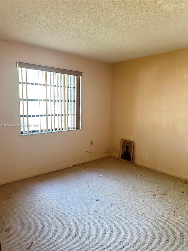 empty room featuring carpet and a textured ceiling