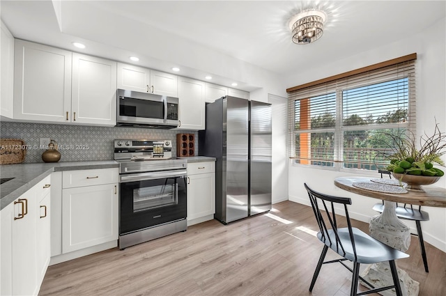 kitchen with white cabinetry, stainless steel appliances, and light hardwood / wood-style flooring