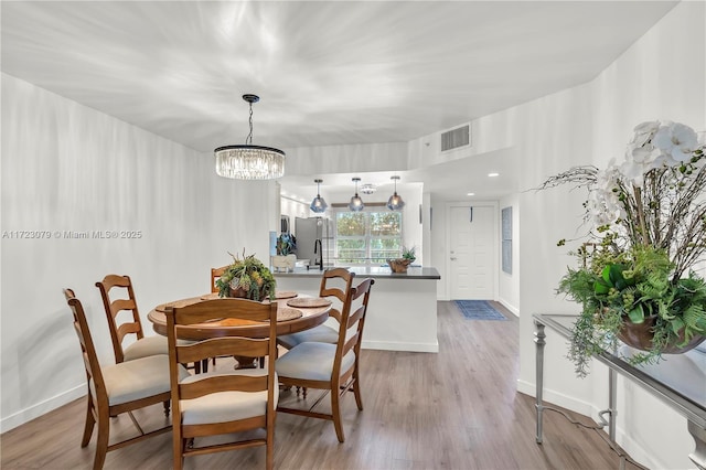 dining room featuring a chandelier and light hardwood / wood-style flooring