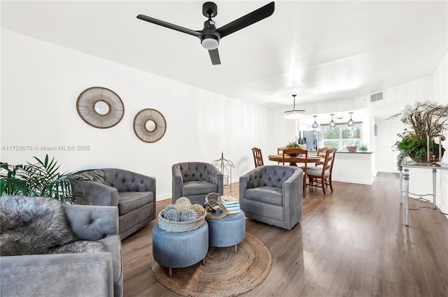 living room featuring ceiling fan and dark wood-type flooring