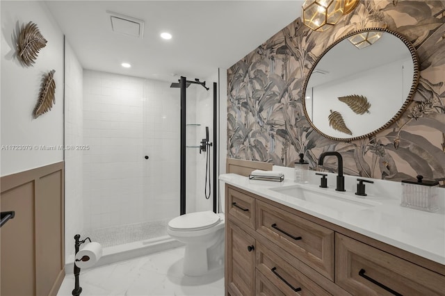 bathroom featuring tiled shower, vanity, and toilet