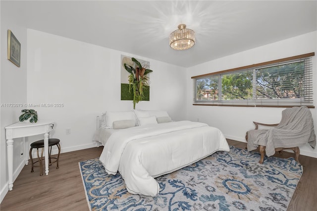 bedroom with hardwood / wood-style flooring and a notable chandelier