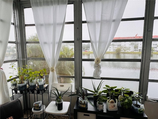 sunroom / solarium featuring a water view and a healthy amount of sunlight