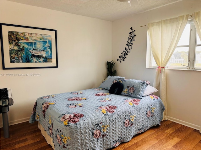 bedroom with wood-type flooring and a textured ceiling