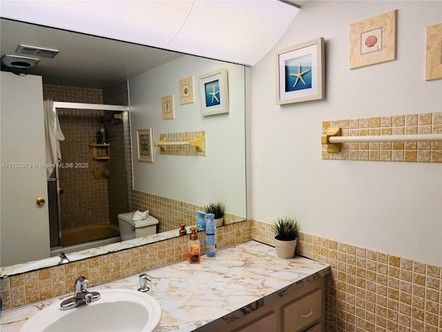 bathroom with vanity, toilet, and a shower with shower door