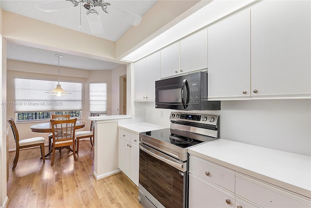 kitchen featuring pendant lighting, white cabinetry, electric stove, and light hardwood / wood-style floors