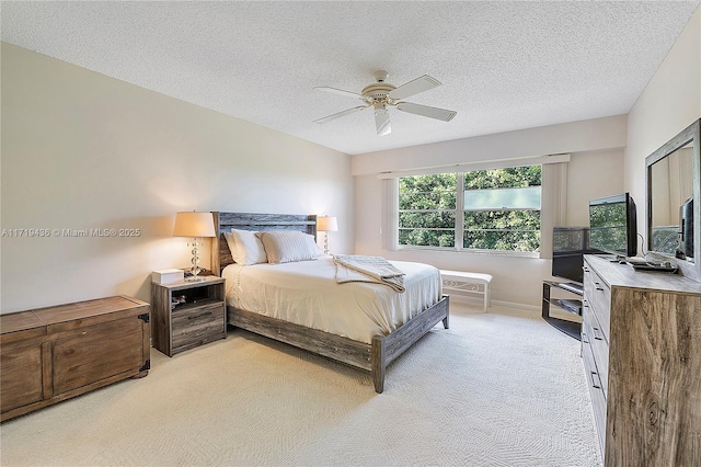 carpeted bedroom with ceiling fan and a textured ceiling