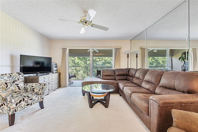 carpeted living room featuring ceiling fan and a textured ceiling