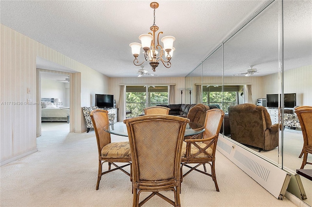 dining space featuring light carpet, a textured ceiling, and ceiling fan with notable chandelier