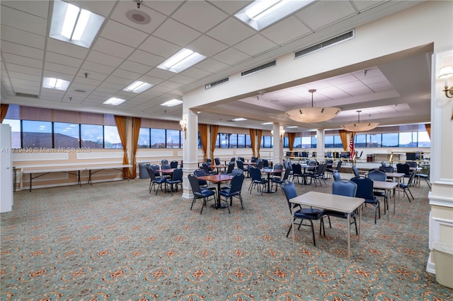 carpeted dining area featuring a drop ceiling