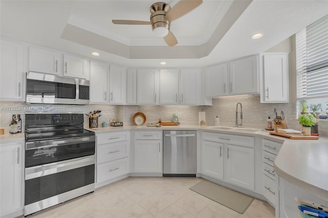 kitchen featuring a tray ceiling, white cabinetry, and appliances with stainless steel finishes