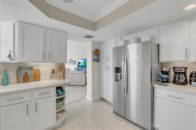 kitchen with white cabinets, ornamental molding, stainless steel refrigerator with ice dispenser, and tasteful backsplash