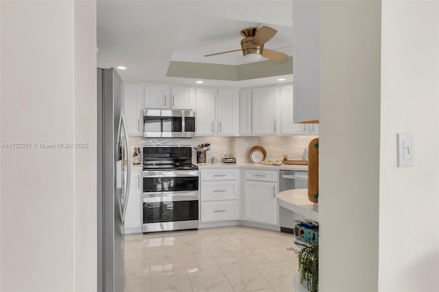 kitchen with white cabinets, decorative backsplash, ceiling fan, and stainless steel appliances