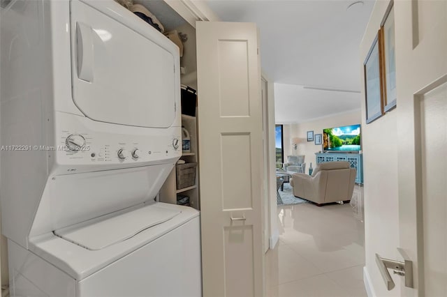 laundry room with light tile patterned floors and stacked washer / dryer