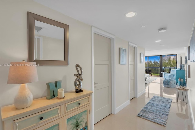 hallway featuring expansive windows and light tile patterned floors