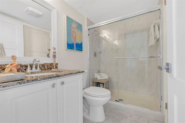 bathroom with tile patterned floors, vanity, an enclosed shower, and toilet