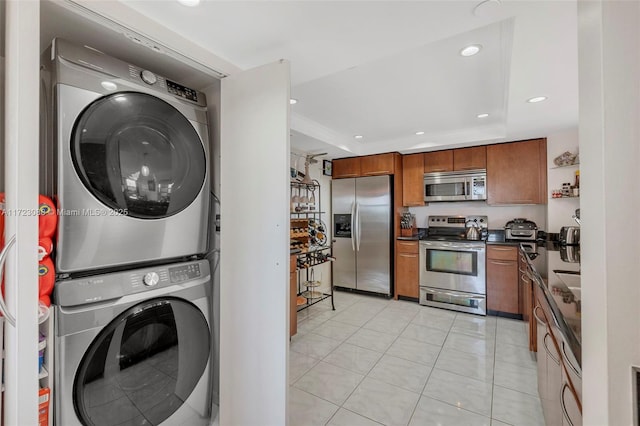 washroom featuring light tile patterned flooring and stacked washer / drying machine